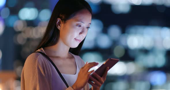 Woman use of mobile phone over the building background