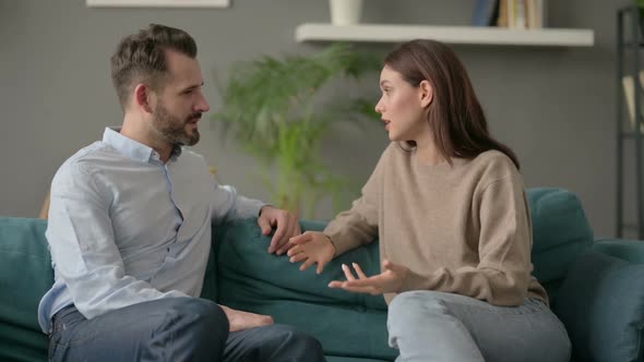 Serious Woman Talking to Man While Sitting on Sofa