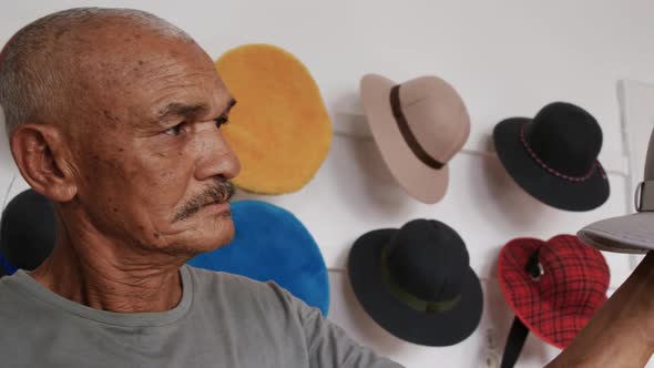 Mixed race man working at a hat factory
