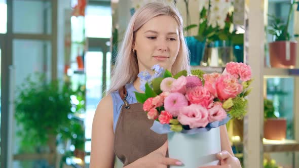 Nice Blonde Lady with Loose Hair Holds Hat Box with Bouquet