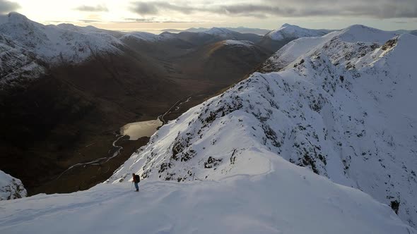 Mountain Climber Surveying a Ridge in the Sunny Afternoon