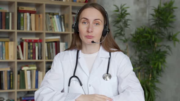 Young Woman Doctor in White Medical Uniform with Stethoscope Talk Video Conference Call with Patient