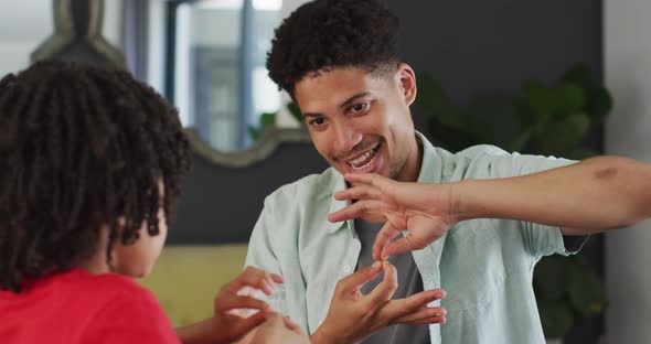 Happy biracial man and his son using sign language