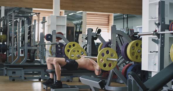 In a Sport Gym Guy Doing the Workout Lifting Up