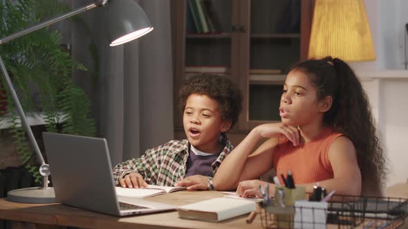 Afro Siblings Studying Online On Laptop