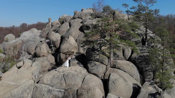 Wedding Day of the Newlyweds on the Rocks. Flying a Drone Around a Young Couple Who Is Standing