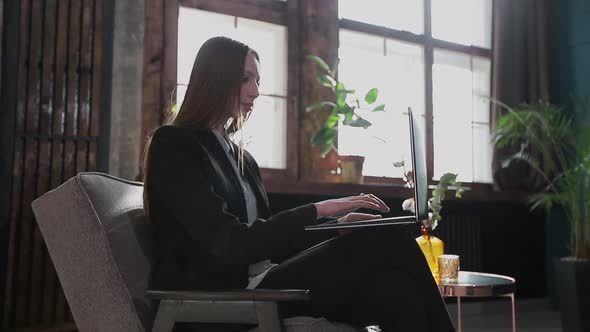 Confident Businesswoman Working on a Laptop in Her Modern Blue Modern Office Interior. Stylish