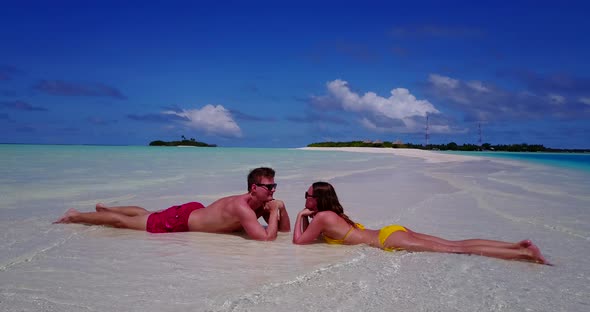 Fun boy and girl on romantic honeymoon spend quality time on beach on sunny white sandy 4K backgroun