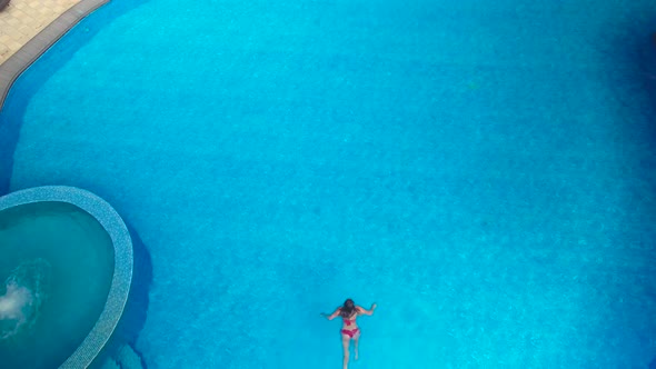 girl dives into the pool red swimsuite