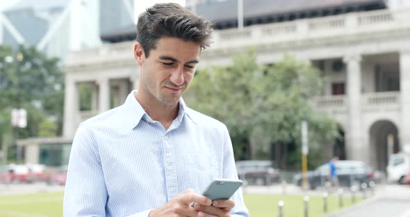 Businessman use of cellphone in Hong Kong city