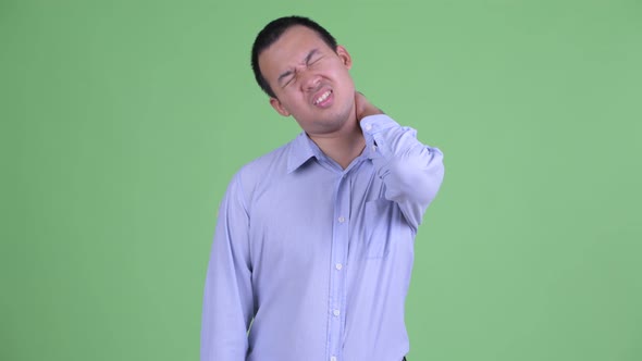 Stressed Asian Businessman Having Neck Pain