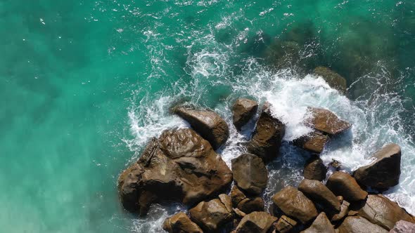 Aerial view of turquoise water crashing over beautiful rocks Mahe Seychelles