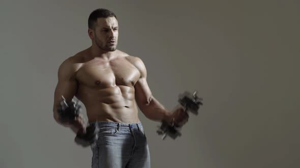 Muscular Man Workiout in Gym Doing Exercises with Dumbbells at Biceps, Strong Male Abs.