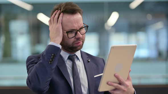 Middle Aged Businessman Reacting to Loss on Tablet