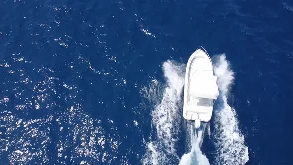 White Speed Boat Sailing Across The Blue Water Of Castellammare Gulf Near The Scopello, Trapani In S