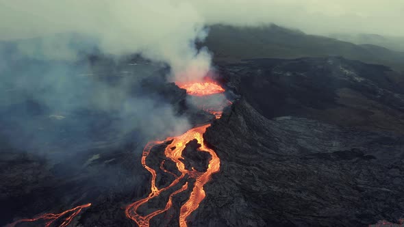 Aerial view around a Volcanic crater, in middle of smoke - circling, drone shot