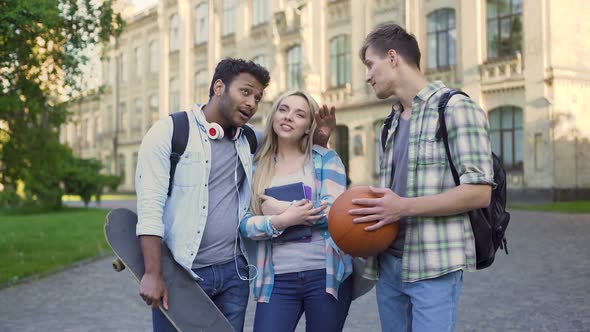 Two Male Students Flirting With Beautiful Blond Girl Near University, Joking