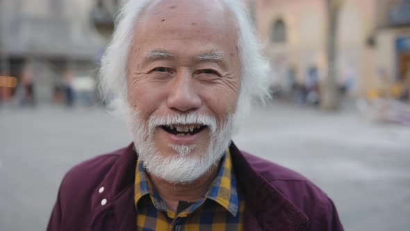 Happy Asian senior man smiling in front of camera