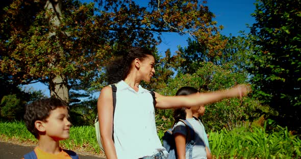 Woman interacting with kids while walking through park