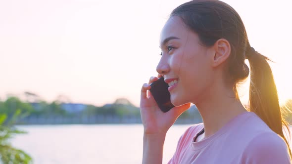 Asian young woman stand outdoor use mobile phone call talk with friend.