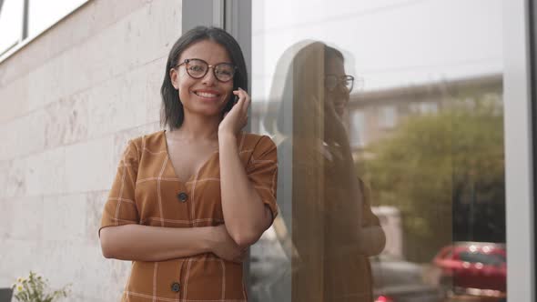 Woman Talking on Phone by Window Outdoors