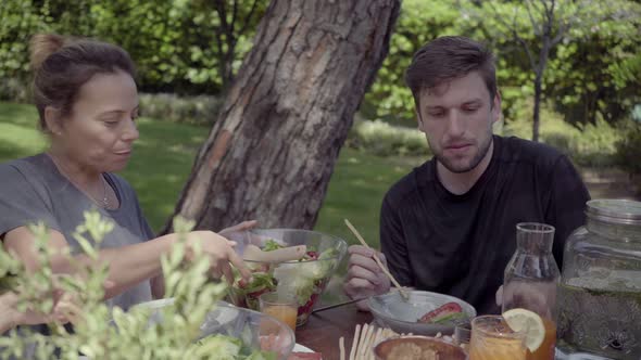Young People Eating Healthy Dishes in Backyard