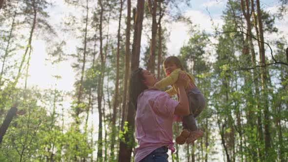 Happy Mother Throws Her Daughter in Nature