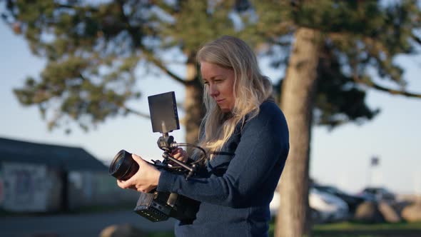 Female Film Maker Adjusting Film Camera Lens