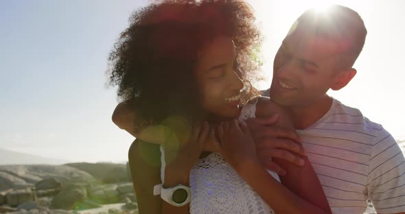 Couple embracing each other on beach in the sunshine 