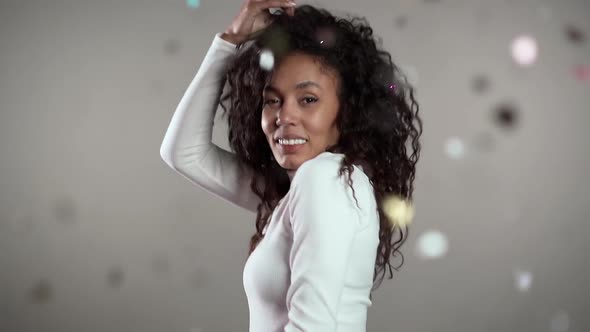 Excited African American Woman Dancing, Having Fun, Rejoices Over Confetti Rain