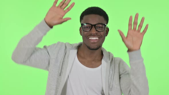 African Man Dancing in Joy on Green Background