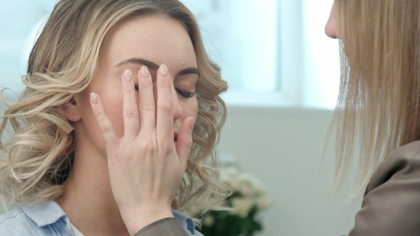 Professional make-up artist applying cream base eyeshadow