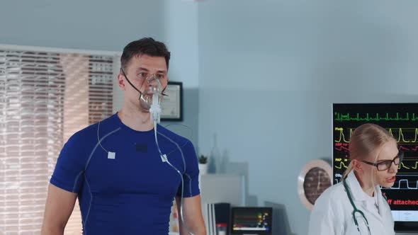 Middle Closeup of Fit Man in Oxygen Mask Walking on Treadmill in Scientific Sports Lab