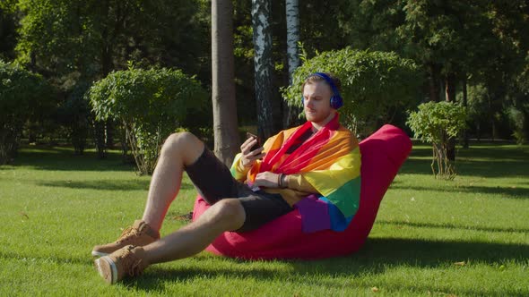 Gay Man in Headphones Enjoying Music in Park