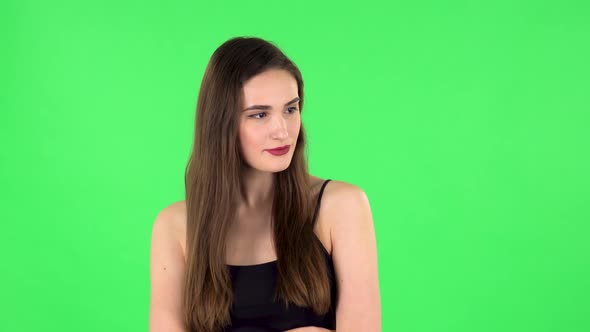 Young Woman Stands Waiting on Green Screen