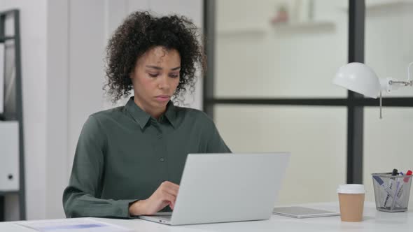 African Woman Thinking While Using Laptop