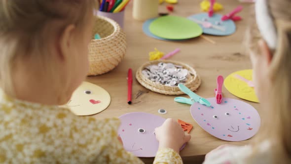 Rear view of two girls making Easter bunnies. Shot with RED helium camera in 8K.