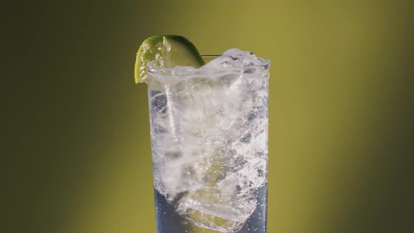 Lime added to a Soda water or a Sprite spinning glass, slow motion bubbles.