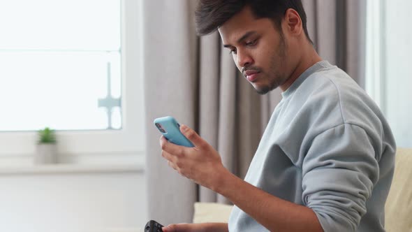 Handsome Indian man looking at phone