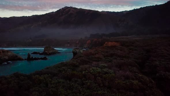 Twilight aerial view of ocean cliffs and beach waves at Sand Dollar Beach in Big Sur California