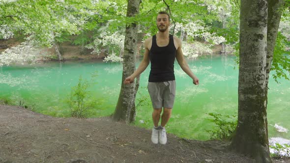 Man doing sports in nature. He's skipping.