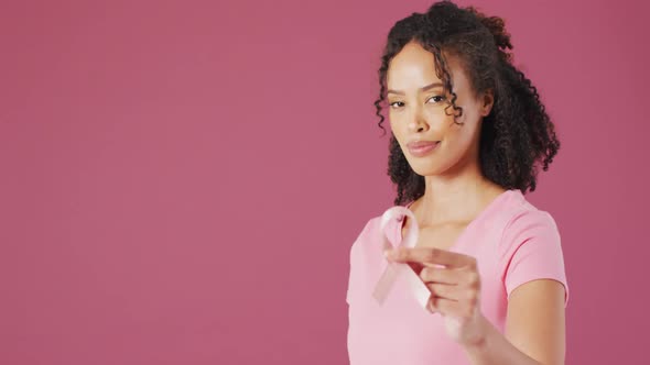 Video of smiling biracial woman holding white lung cancer ribbon