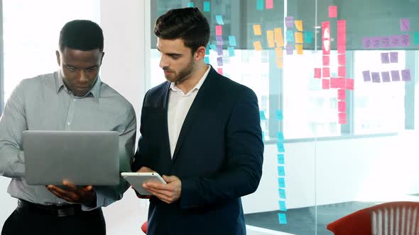 Male executives using laptop and digital tablet 4k