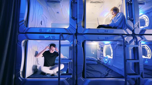 Young Man and Woman in the Capsule Hotel Rooms