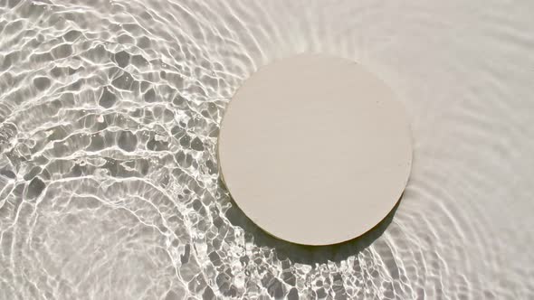 Empty White Circle Podium on Transparent Clear Water Texture with Waves in Sunlight