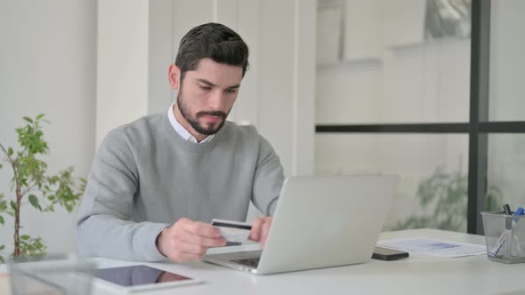 Young Man Making Online Payment Failure on Laptop in Office