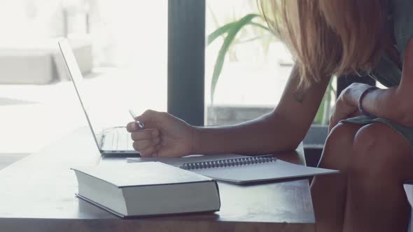 Long-haired Person Writing in Notebook