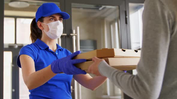 Delivery Girl in Mask Giving Pizza Boxes To Woman
