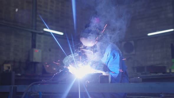 asian male technician worker in a dressed in protective uniform welding metal frame