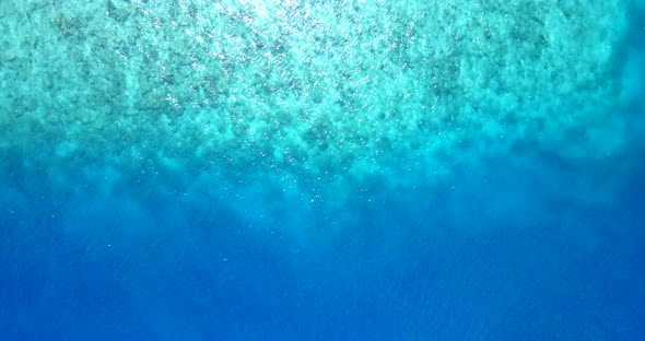 Wide birds eye travel shot of a white paradise beach and aqua turquoise water background in colorful